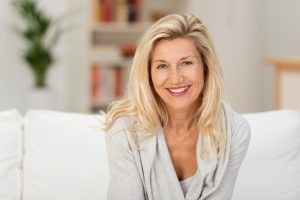 Middle Aged Blonde Woman Smiling On Sofa